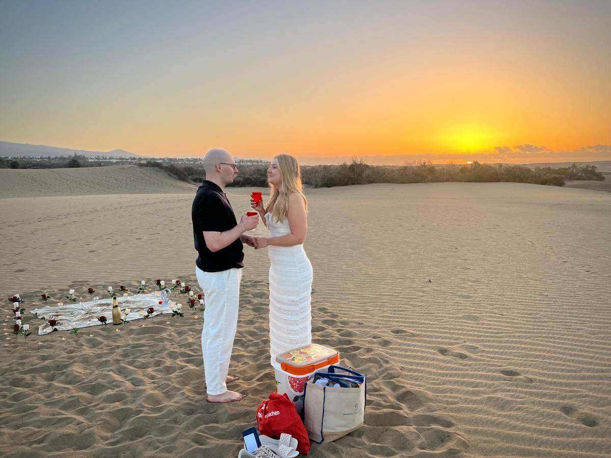 Paar bei einem persönlichen Heiratsantrag in den Dünen von Gran Canaria bei Sonnenuntergang